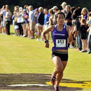 A University of Montevallo cross country runner crosses the finish line during a race on the UM course.