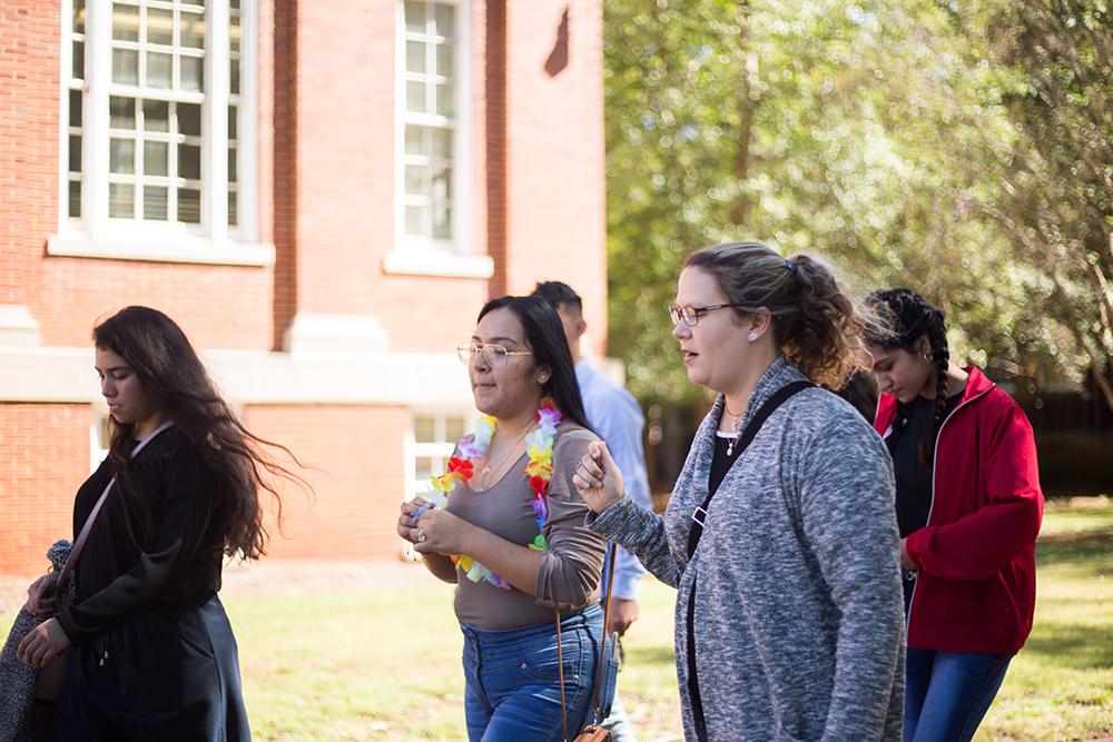 Montevallo students having a conversation while walking on a brick street.